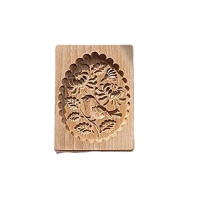 Wooden cookie stamp with floral design on a white background