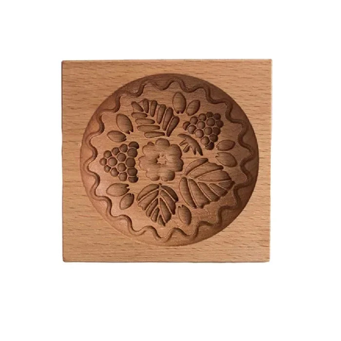 Wooden stamp with floral and leaf design on a white background