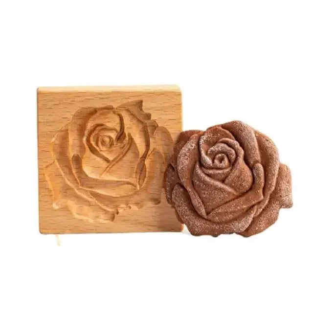 Wooden mold with rose design next to a rose-shaped soap on a white background