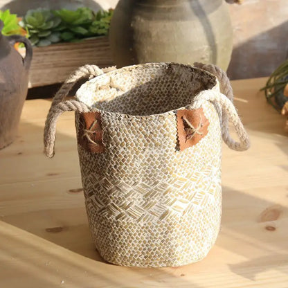 Woven basket with leather straps on a wooden surface