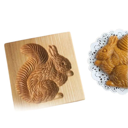 Wooden mold shaped like a squirrel with a chocolate bar molded into the shape of a squirrel.